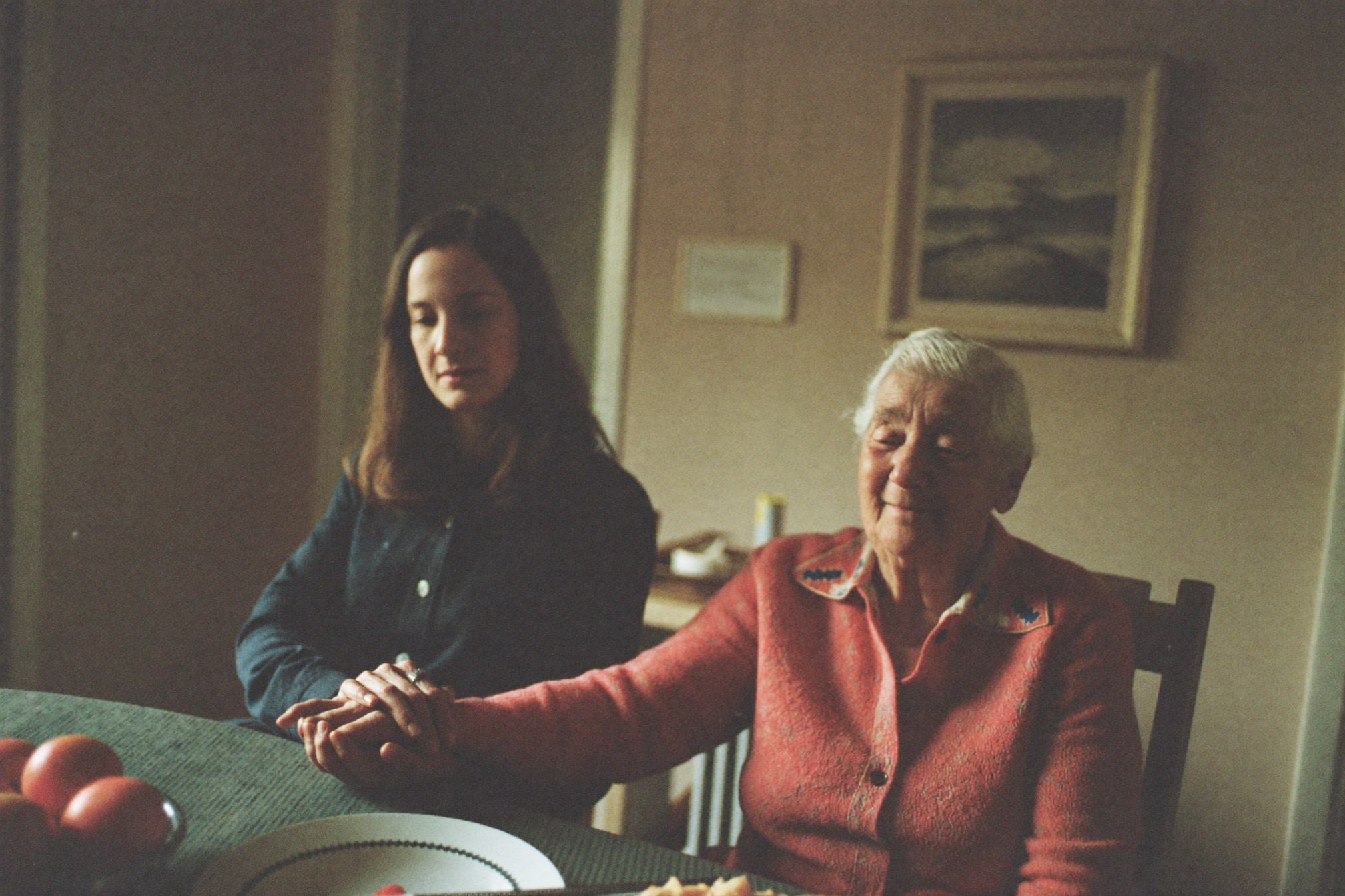 A woman holding her elderly mother's hand
